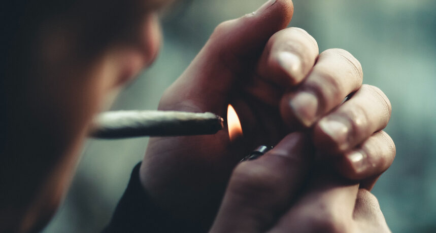mężczyzna zapalający jointa z marihuaną