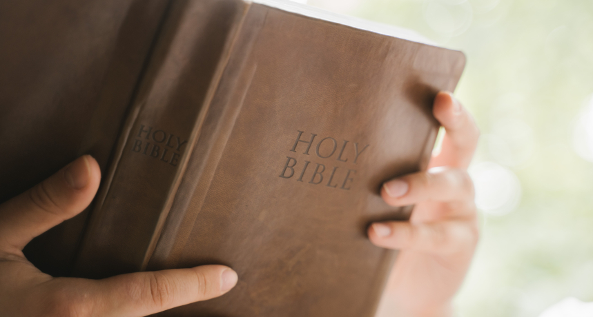 kobieta trzymajaca otwarta biblie w dloniach